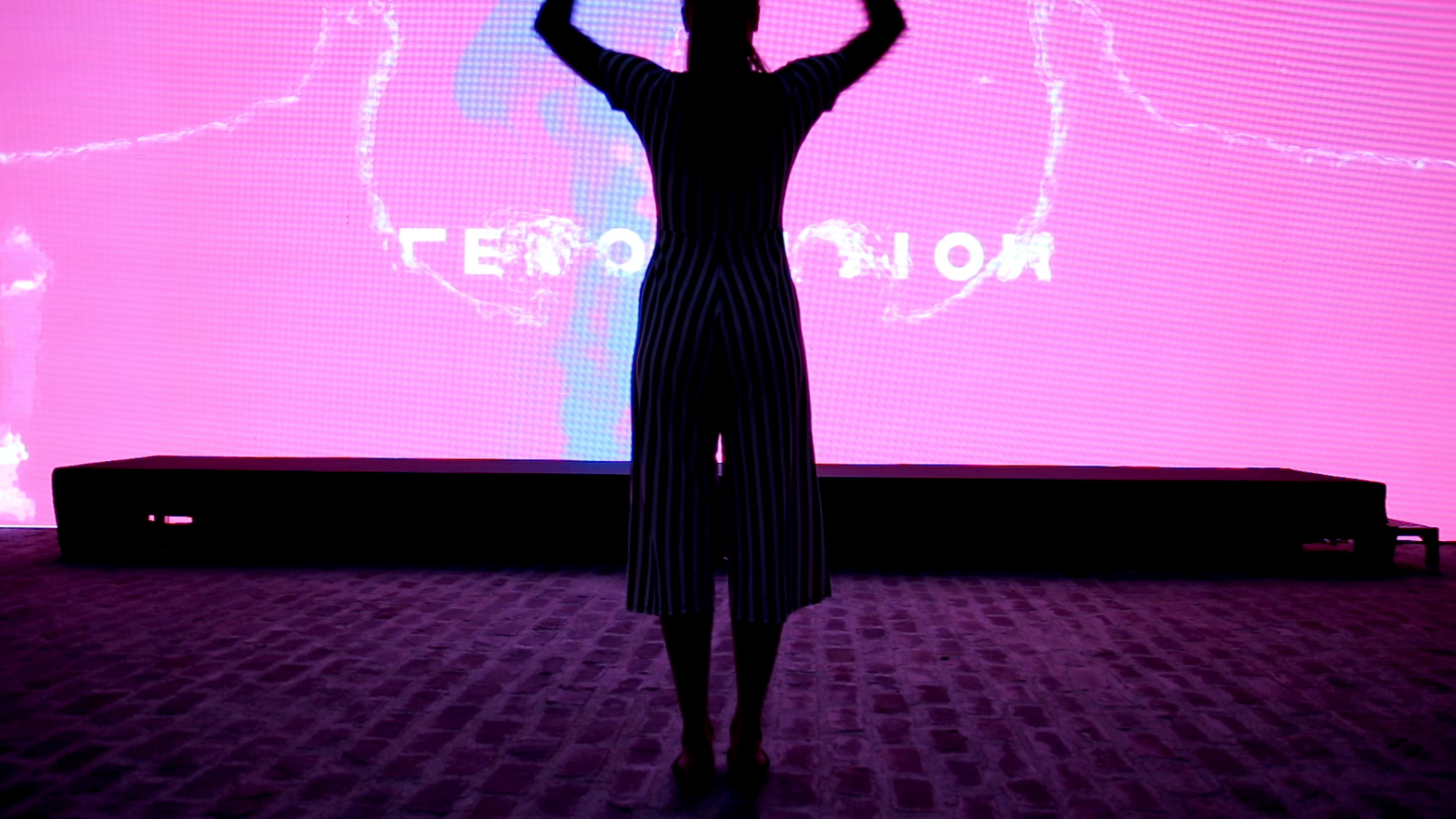 A person waving its arms to a giant screen with virtual water